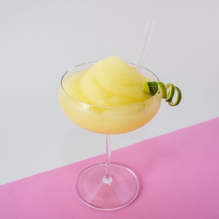 Cóctel de daiquiri congelado, servido en una copa de cocktail con una rodaja de lima en el borde.